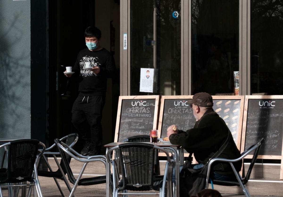 El cambrer d'un bar amb una mascareta com a mesura de precaució pel coronavirus